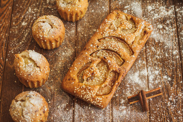 Cake with pears and sesame on dark wooden background