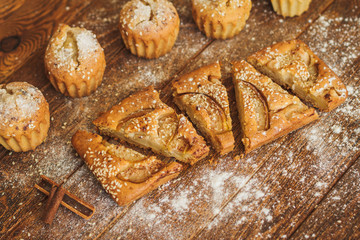 Slices of cake with pears and sesame on dark wooden background