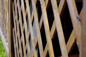 Wooden slatted fence. Part of the open wooden veranda. Background.