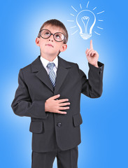Fototapeta na wymiar Little schoolboy with idea bulb above the head on blue background