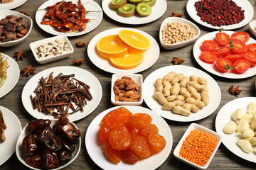 Different products on saucers on wooden table, closeup