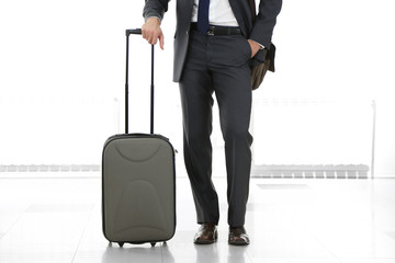 Man holding suitcase on light background