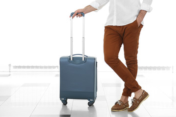 Man holding suitcase on light background