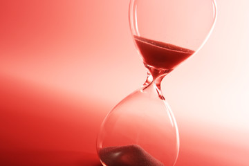 Fototapeta na wymiar Hourglass on pink background