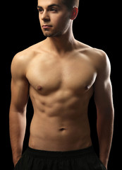 Fototapeta premium Muscle young man on dark background