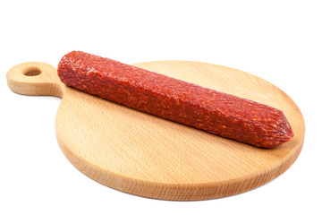 Stick sausage on a wooden cutting board.