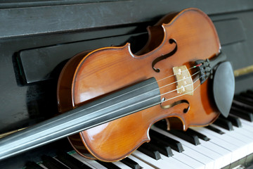 Fototapeta premium Violin on piano keys, closeup