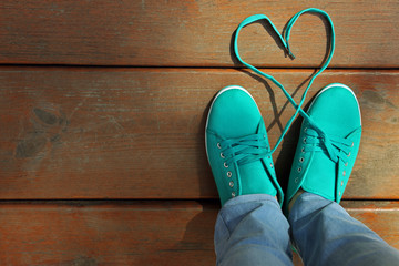 Female feet in gum shoes on wooden floor background