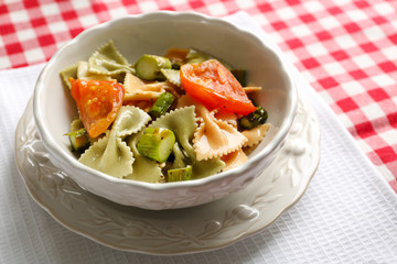 Roasted asparagus and tasty pasta with vegetables in bowl on wooden table background