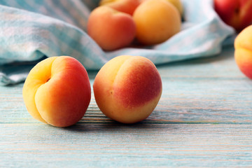 Ripe apricots with napkin on wooden table close up