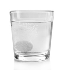 Pill in glass of water on light background