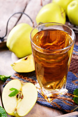 Glass of apple juice with fruits and fresh mint on table close up