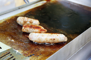 Sausages cooking in frying pan close up