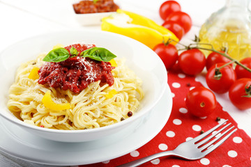 Spaghetti with tomato sauce and cheese on white plate, on color wooden background