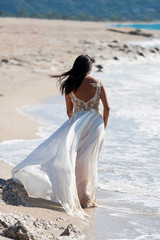 Fototapeta na wymiar bride in her snow-white dress on the beach