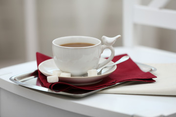 Cup of tea on chair in room