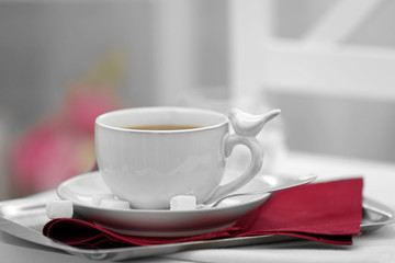 Cup of tea on chair in room