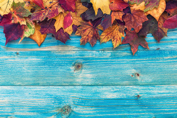 Naklejka na ściany i meble Autumn background with colorful leaves on wooden background