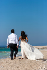 bride and groom, together in sunshine on a beautiful tropical be