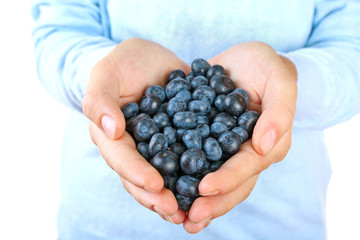 Female hand holding tasty ripe blueberries close up