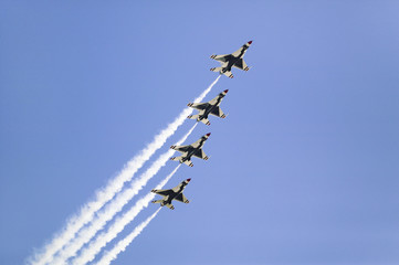 Four US Air Force F-16C Fighting Falcons, known as the Thunderbirds, flying in formation with white trailer of smoke over the 42nd Naval Base Ventura County (NBVC) Air Show at Point Mugu, Ventura County, Southern California.