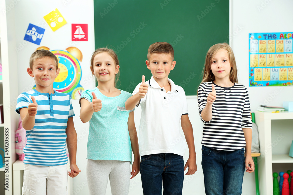 Wall mural Portrait of happy classmates looking at camera in classroom