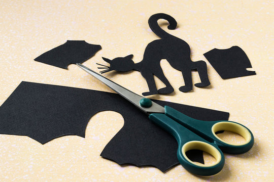Cutting paper symbols of Halloween - black cat