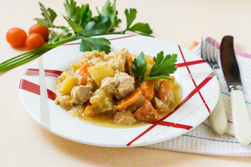 Steamed vegetables in a plate and cutlery on the table