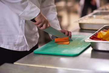chef in hotel kitchen  slice  vegetables with knife