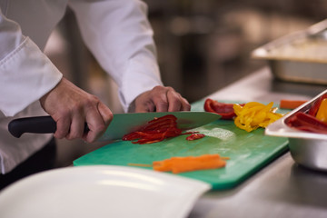 chef in hotel kitchen  slice  vegetables with knife