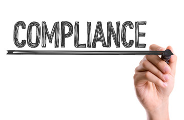 Hand with marker writing the word Compliance