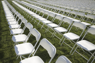 Rows of empty white chairs in grassy field in Washington, DC