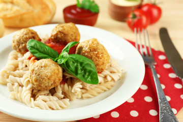 Pasta with meatballs on plate, on wooden  table background