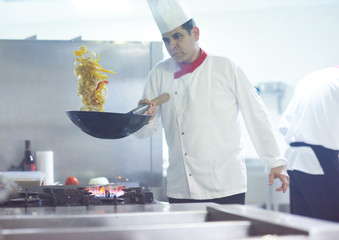 chef in hotel kitchen prepare food with fire