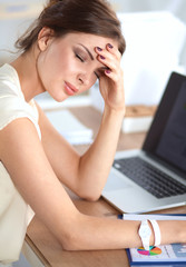 Fototapeta premium Portrait of tired young business woman with laptop computer at