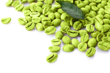 Heap of green coffee beans with leaf isolated on white