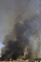Brush fire in desert emitting large black plumes of smoke, east of Needles in Arizona