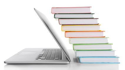 Stack of books with laptop isolated on white