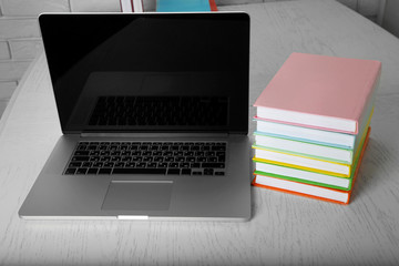 Stack of books with laptop on table close up