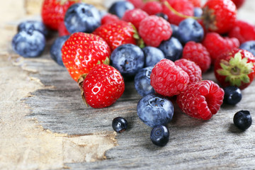 Heap of sweet tasty berries on wooden table close up
