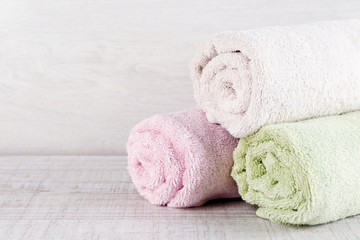 Stack of colorful towels on light background