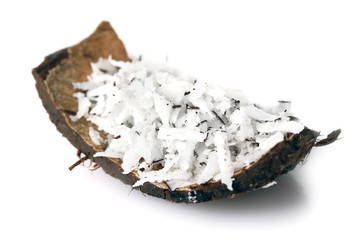 Coconut shavings in coconut shell on white background