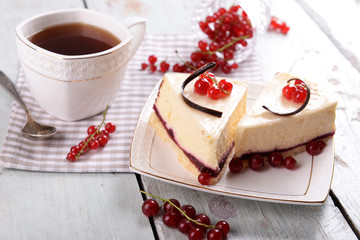 Tasty cheesecake with berries and cup of tea on table close up