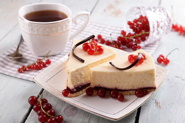 Tasty cheesecake with berries and cup of tea on table close up