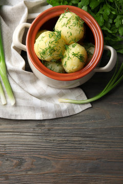 Boiled potatoes with dill in pan on table close up