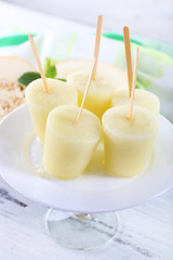 Melon ice lolly on wooden table, closeup