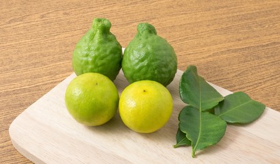 Green Kaffir Lime with Lemon Lime on Wooden Board