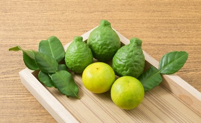 Green Kaffir Lime with Lemon Lime on Wooden Tray