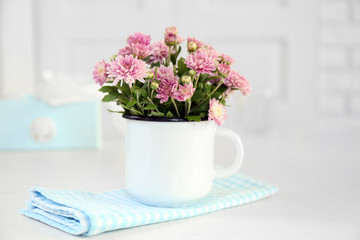 Beautiful flowers in vase on table, on light background
