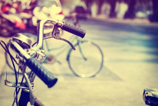 Detail of a Vintage Bicycle Handlebar Resting in the city Street (vintage color tone image)